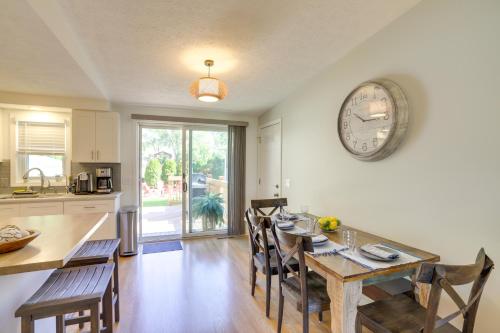 a kitchen and dining room with a table and a clock on the wall at Three Oaks Home with Guest House - 8 Mi to Beach! in Three Oaks