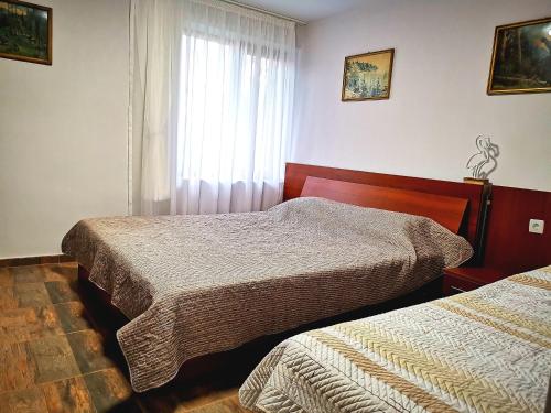 a bedroom with two beds and a window at Студио за гости - Лили in Ognyanovo