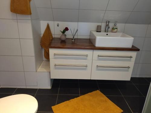 baño con lavabo blanco y encimera blanca en Bambina's Guest House, en Kristianstad