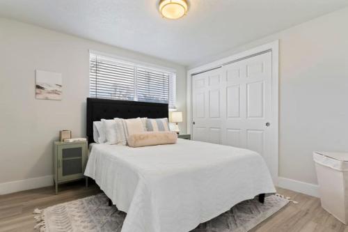 biała sypialnia z dużym łóżkiem i oknem w obiekcie Amazing New Condo Great Location ! Sugarhouse w mieście South Salt Lake