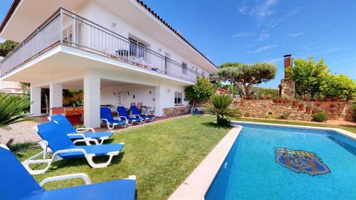 Villa con piscina y sillas azules en VILLA VALENTINA en Mataró