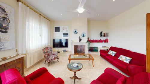 a living room with a red couch and a fireplace at VILLA VALENTINA in Mataró