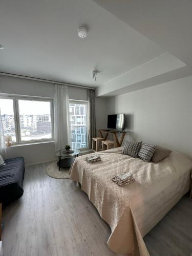 a bedroom with a large bed and a couch at Pramea Apartments Tornitupa in Kuopio