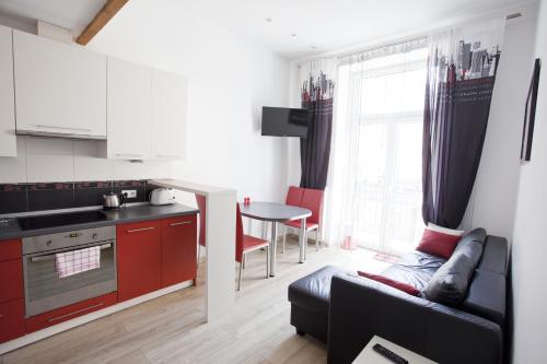 kuchnia i salon z kanapą i stołem w obiekcie Rent-Apart City Center Lodz w Łodzi