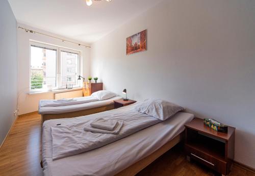 2 camas individuales en una habitación con ventana en Lodz4rent - Premium Apartment - PIOTRKOWSKA - Garaż - Wakacje 2024 en Lodz