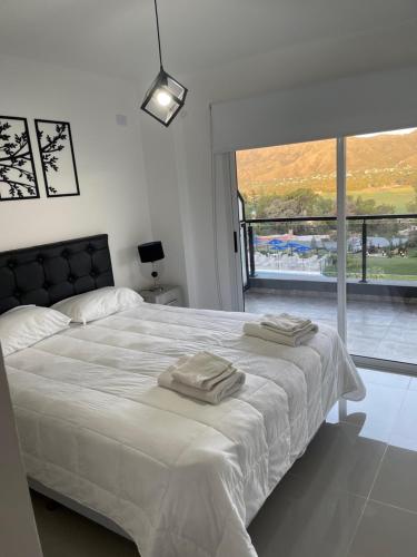 a bedroom with a bed with two towels on it at Veneto Village in Villa Parque Siquiman