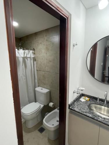 a bathroom with a toilet and a sink and a mirror at Veneto Village in Villa Parque Siquiman