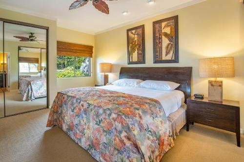 a bedroom with a large bed and a mirror at Kapalua Villas Maui in Lahaina