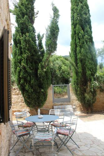 a patio with a table and chairs and trees at Magnificent, Authentic Private Villa and the Guest house in Kardamili