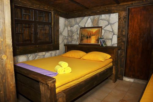 ein Schlafzimmer mit einem Bett mit gelben Kissen darauf in der Unterkunft Skadar Lake House Virpazar in Virpazar