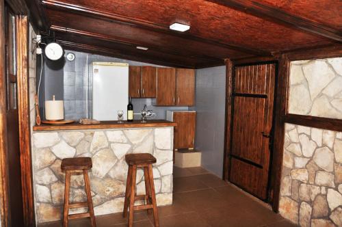 eine Küche mit einer Steintheke und 2 Hockern in der Unterkunft Skadar Lake House Virpazar in Virpazar