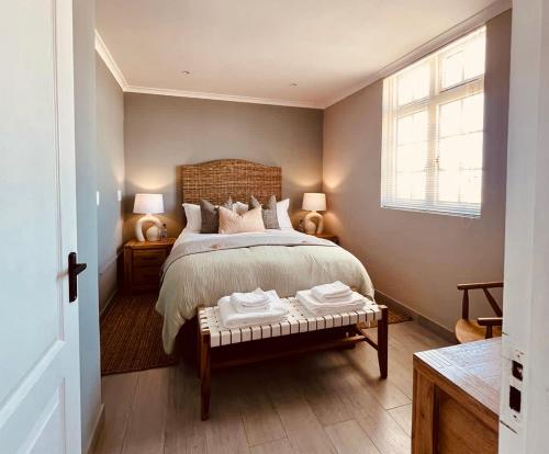 een slaapkamer met een bed, 2 lampen en een raam bij Cape Recife Lighthouse Luxury Villa in Port Elizabeth