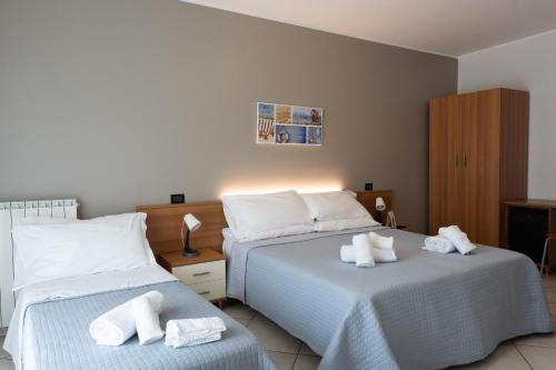 1 dormitorio con 2 camas y toallas. en Hotel D'Atri en Montesilvano