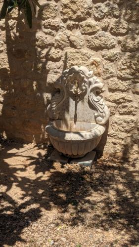 a stone fountain in front of a stone wall at Magnificent, Authentic Private Villa and the Guest house in Kardamili