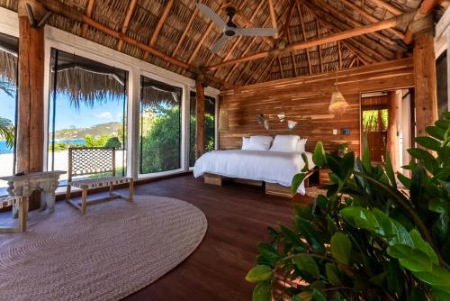 een slaapkamer met een bed en grote ramen bij The Aerial, BVI All-Inclusive Private Island in Tortola Island