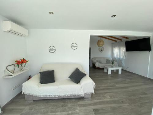 a white room with a bed and a television at Entre montañas in Árchez