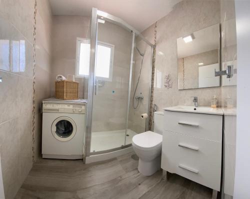 a bathroom with a washing machine and a washer at Entre montañas in Árchez