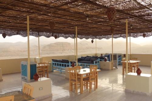 a room with tables and chairs and a view of the desert at Royal Mountain in Luxor