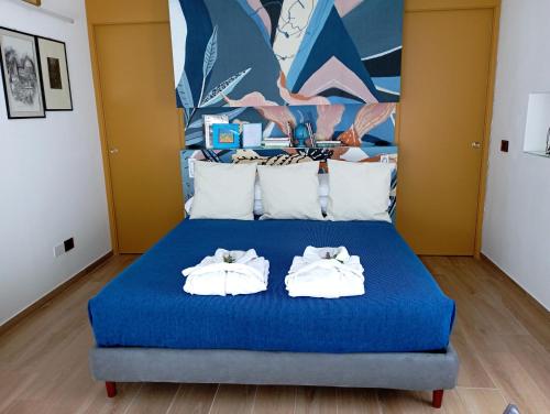 1 dormitorio con 1 cama azul y 2 toallas en VILLA LUNA, en Comeana