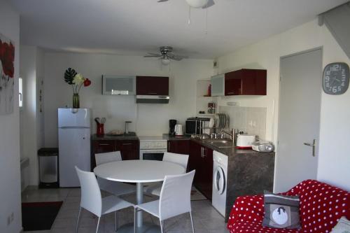 a kitchen with a table and chairs in a kitchen at Villa à deux pas de la cité médiévale dans une résidence très calme in Aigues-Mortes