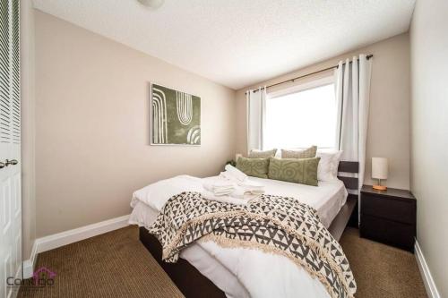 sypialnia z dużym łóżkiem i oknem w obiekcie Cozy 3BD w/AC, Patio, Theatre Room, 15 min to DT w mieście Edmonton