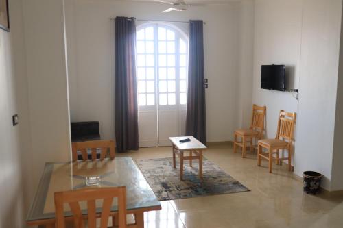 a living room with a table and chairs and a window at Royal Mountain in Luxor