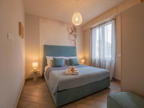 a bedroom with a bed with a blue headboard and a window at Appartamento Melograno "A Casa Felice" in Pietra Ligure