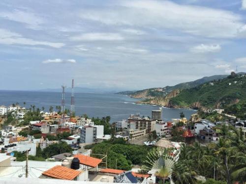 a view of a city and a body of water at Villa Palmitas acogedor departamento nivel piscina gigante jardines in Acapulco