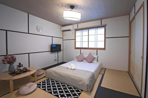 a bedroom with a bed and a table and a window at -時の宿 二条- 二条城前駅 Toki Nijo RoomA in Kyoto