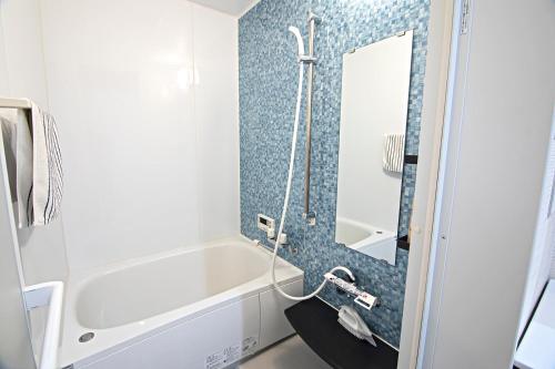 a bathroom with a white tub and a shower at -時の宿 二条- 二条城前駅 Toki Nijo RoomA in Kyoto
