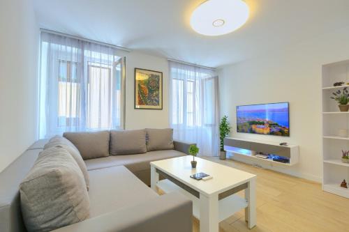 Apartment Tale - Brand new apartment in Pula's old town, with free Netflix and Wi-Fi في بولا: غرفة معيشة مع أريكة وطاولة