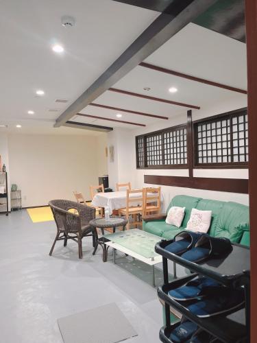 a living room with a green couch and a table at ひまわりHotel in Nagasaki