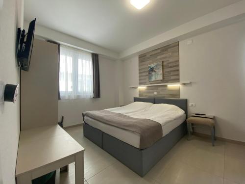 um quarto com uma cama e uma mesa em Villa Manteo em Ohrid
