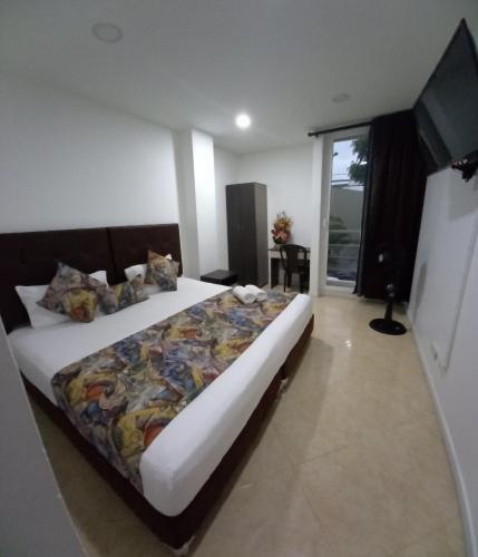 sypialnia z dużym łóżkiem i telewizorem w obiekcie HOTEL RAI MEDELLIN w mieście Medellín