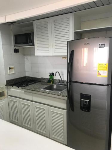 a kitchen with a stainless steel refrigerator and a sink at apartasuitte poblado 607 in Medellín
