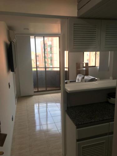 a room with a bed and a kitchen with a window at apartasuitte poblado 607 in Medellín