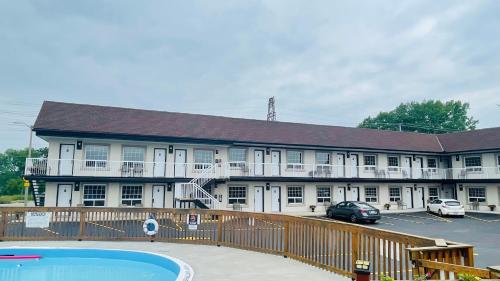 a large building with a pool in front of it at Falls Lodge by the Falls (Formerly Knights Inn) in Niagara Falls