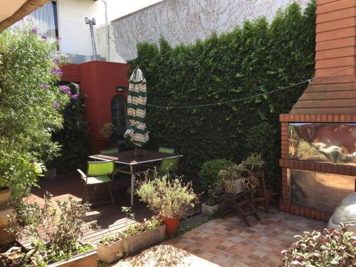 a garden with a table and chairs and a hedge at PH Solís in Mar del Plata