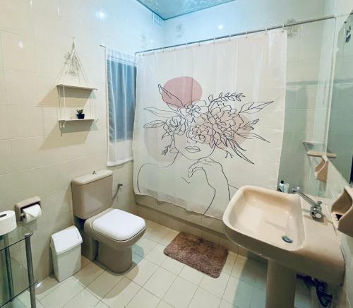 a bathroom with a toilet and a sink and a shower curtain at St Julian Rainbow in St Julian's