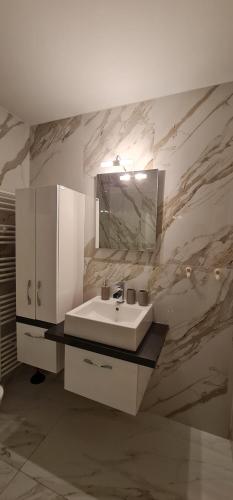 a bathroom with a white sink and a mirror at Euphoria luxury penthouse in Kavala