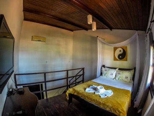 1 dormitorio con 1 cama con colcha amarilla en Enseada dos Mares Beach Bungalows en São Miguel do Gostoso