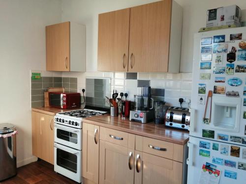 a kitchen with wooden cabinets and a white refrigerator at Angelica place in Portsmouth