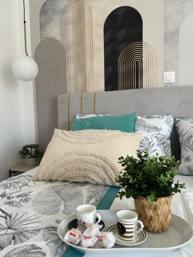 a tray with cups and saucers on a bed at Luxury apartment Golden Mint in Novalja