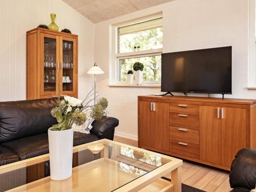 a living room with a couch and a flat screen tv at 6 person holiday home in Bl vand in Ho