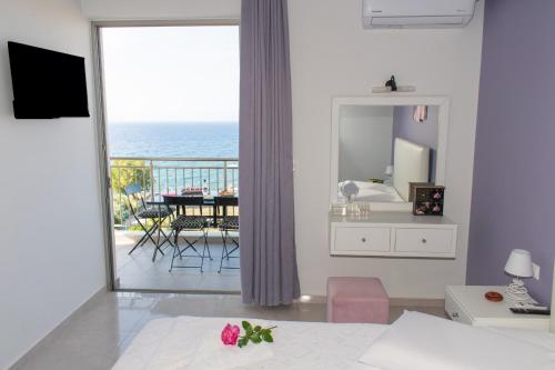 a bedroom with a view of the ocean from a balcony at Akontio Apartment with Sea View in Panormos Rethymno