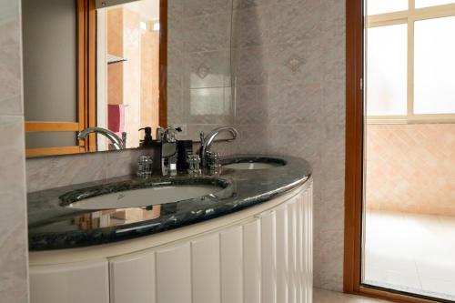 uma casa de banho com um lavatório e um espelho em Da Elisa em Quartu SantʼElena