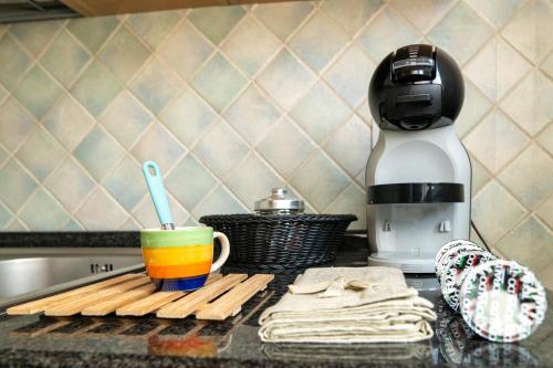 a coffee cup sitting on a counter next to a coffee maker at Appartamento Da Elisa in Quartu SantʼElena