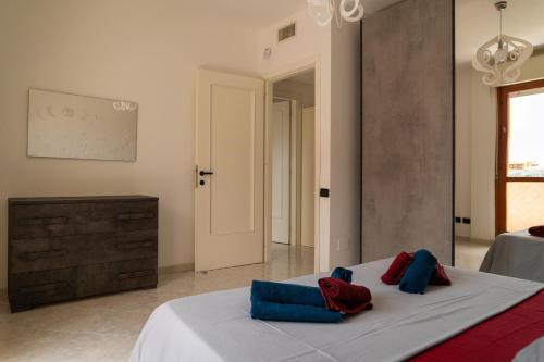 um quarto com uma cama com almofadas azuis e vermelhas em Da Elisa em Quartu SantʼElena