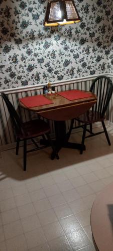 a dining room table and two chairs with a red napkin at Lovely Room in Huntington