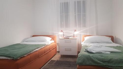 a bedroom with two beds and a night stand with a lamp at In the nature by Marko in Benkovac